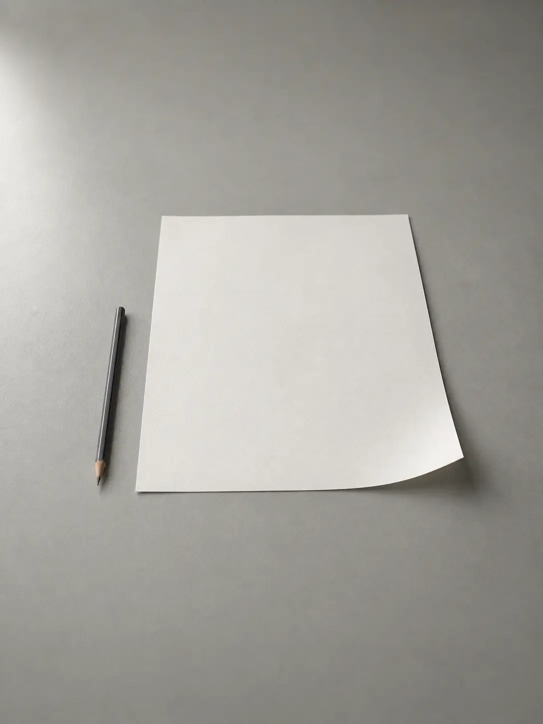 An unmarked page and a pencil on a desk
