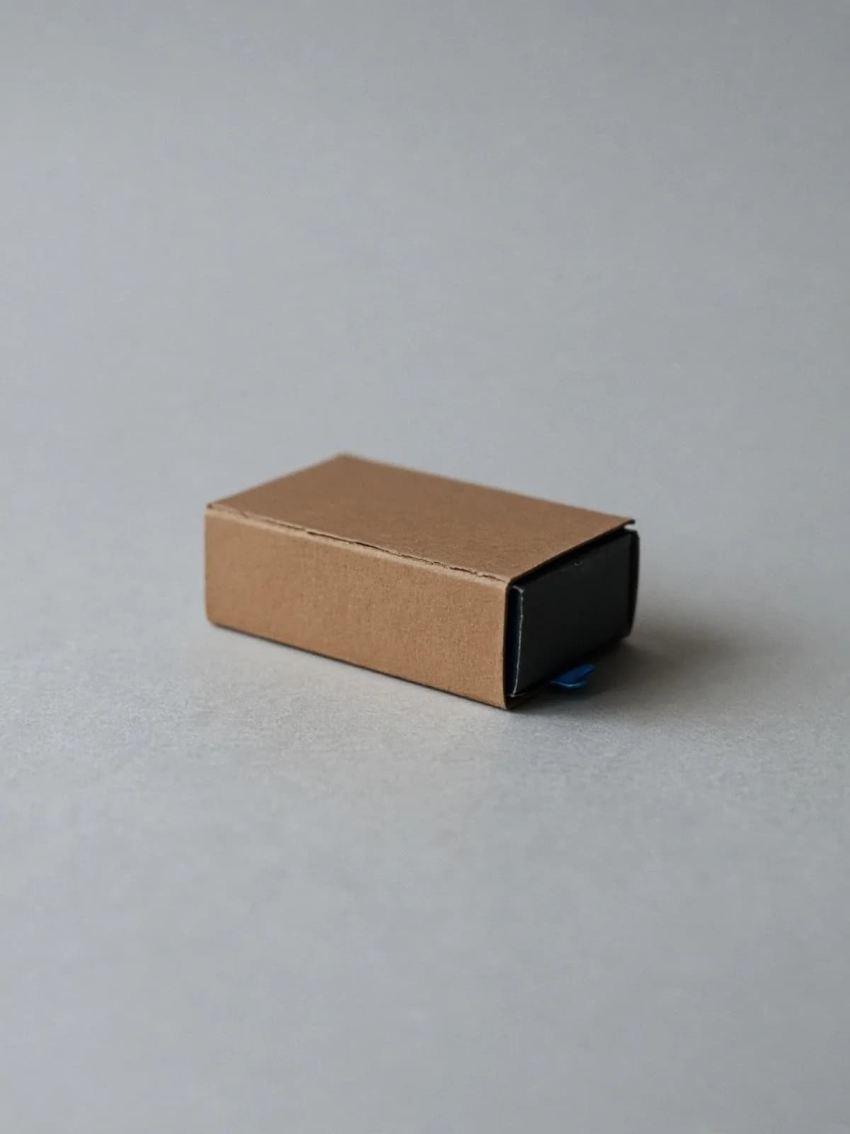 A closed matchbox lying on its side on a desk