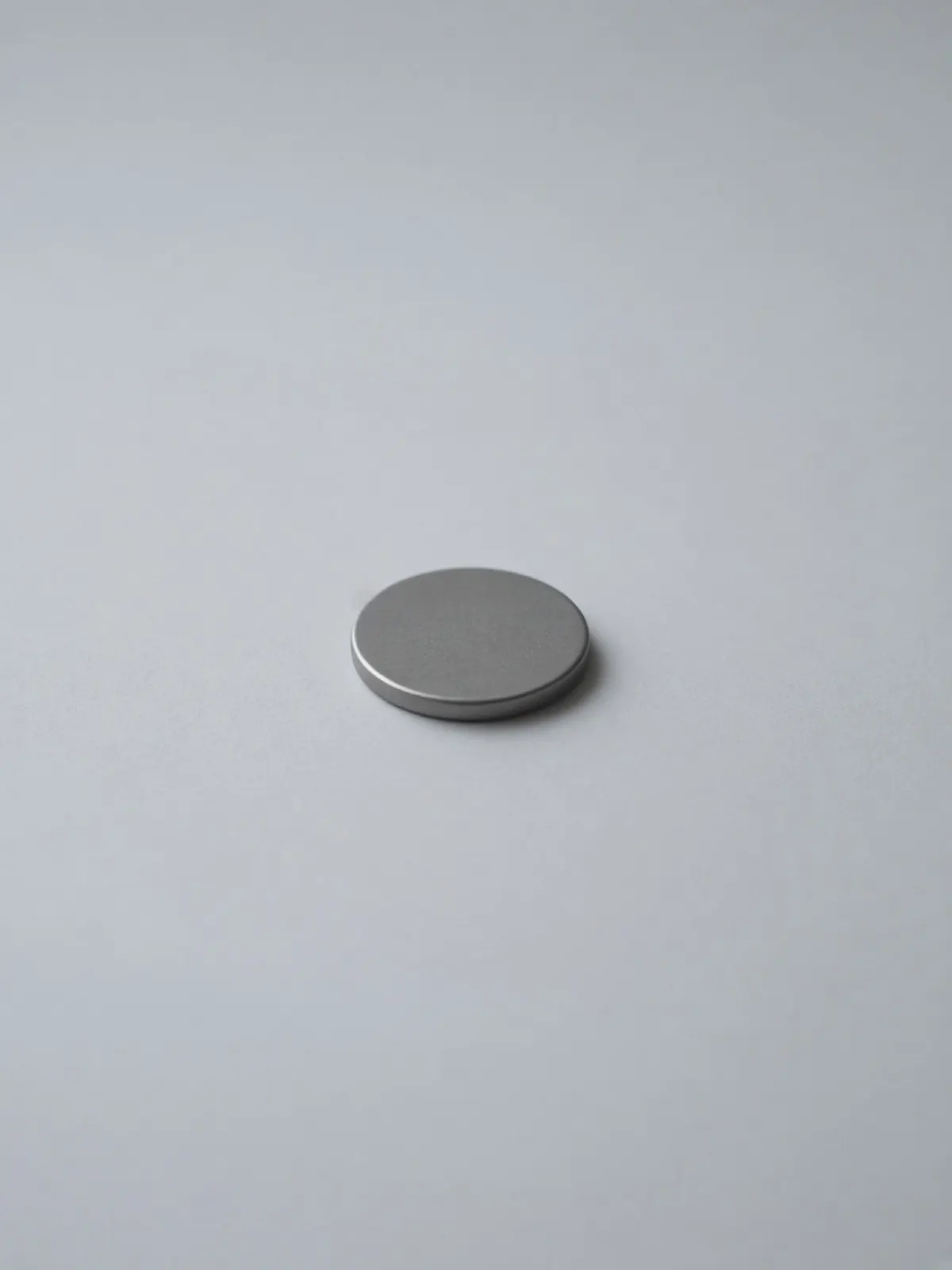 A plain steel coin lying flat on a desk