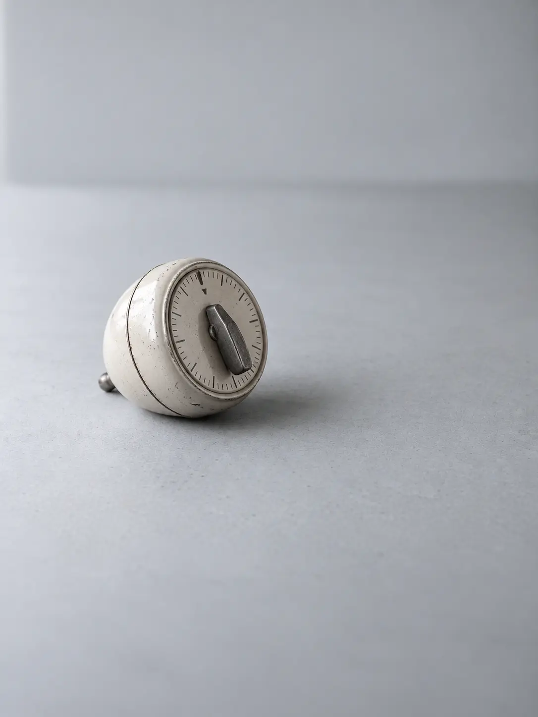 A mechanical kitchen timer lying on its side on a desk