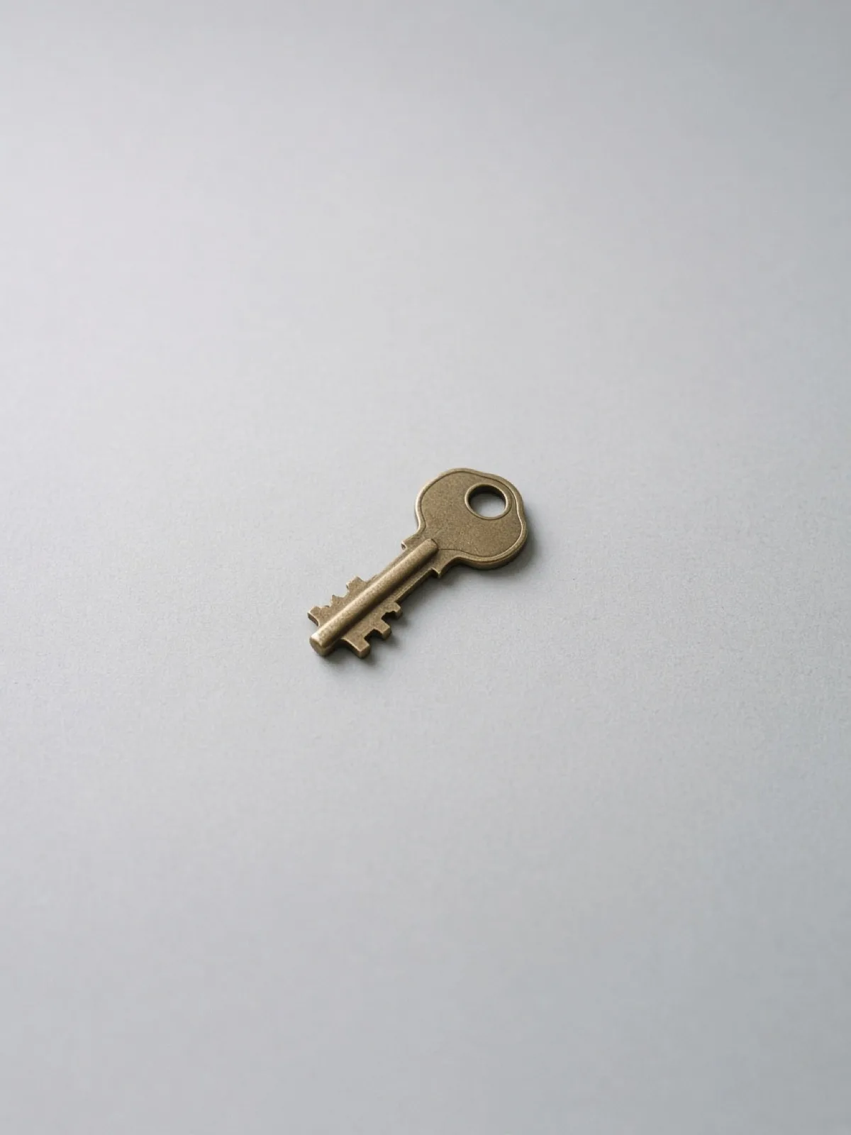 A single brass key lying flat on a desk