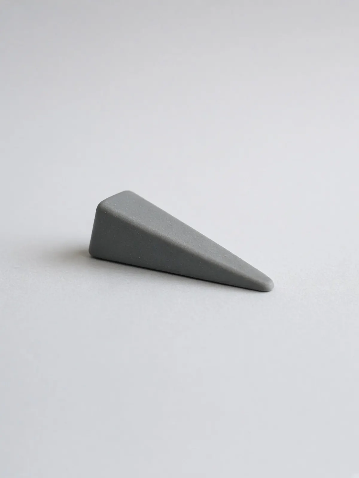 A grey rubber door wedge lying on its side on a desk