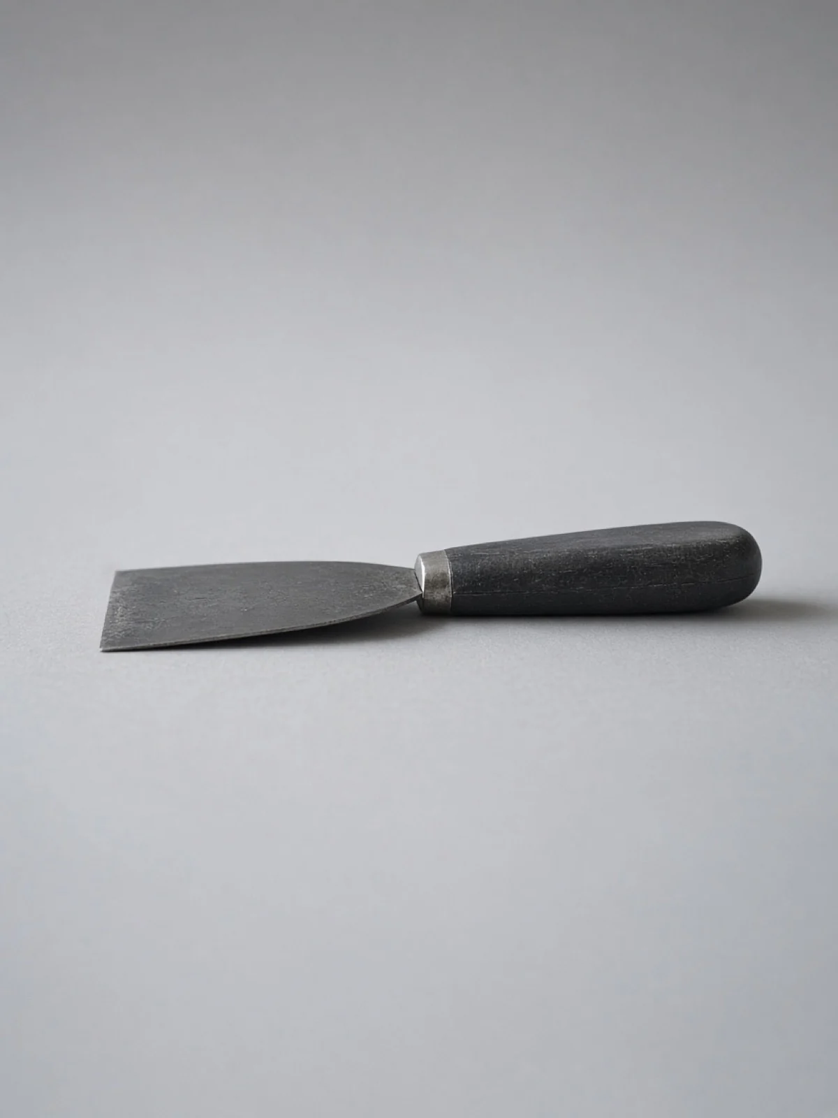 A putty knife lying on its side on a desk