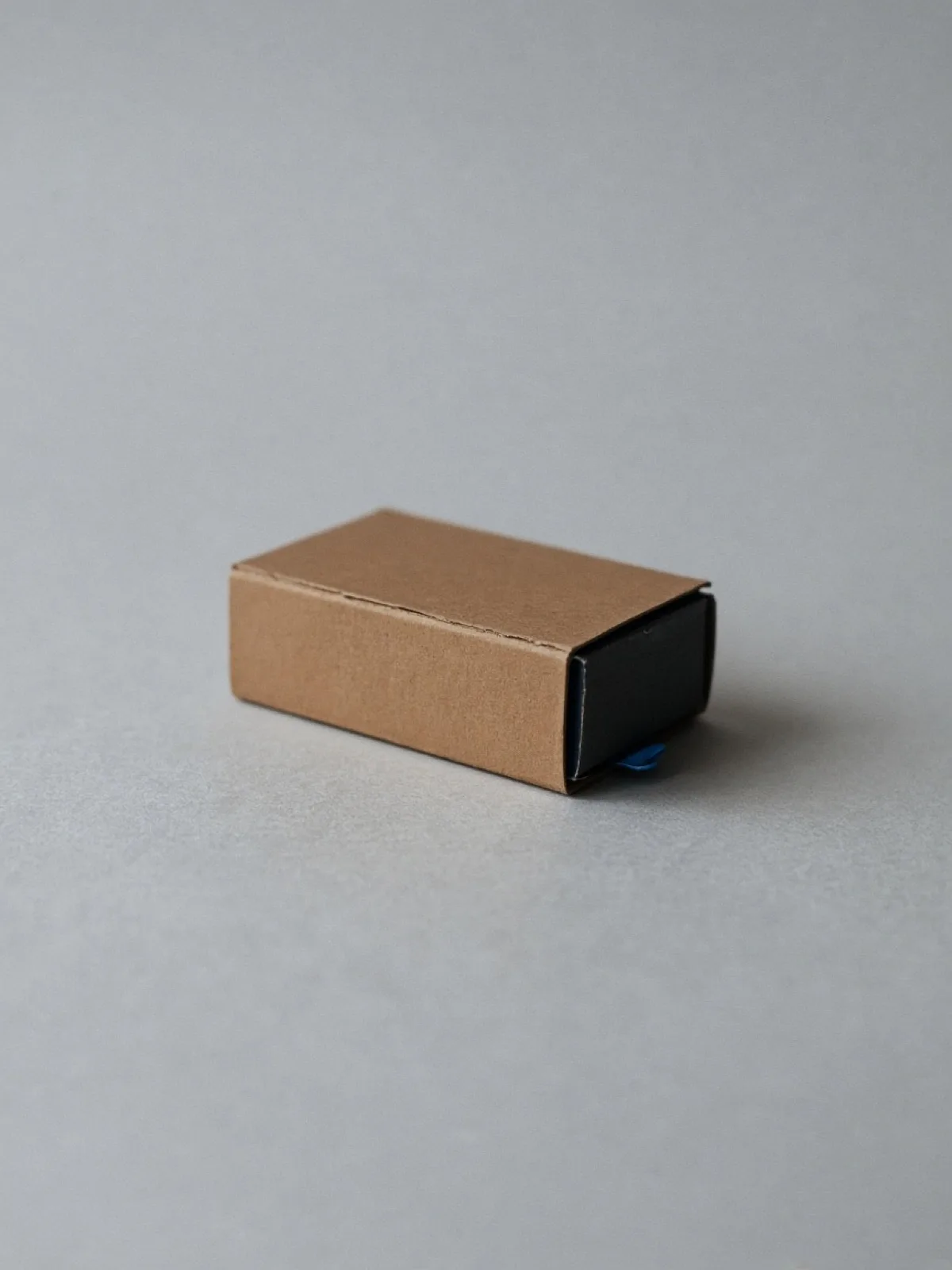 A closed matchbox lying on its side on a desk