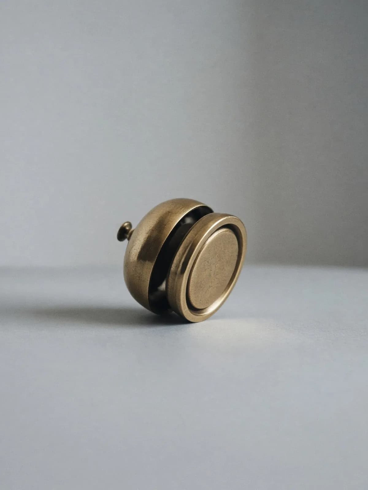 A small brass desk bell lying on its side on a desk